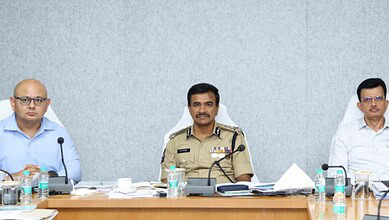 Senior police officer and officials seated at a conference table during a formal meeting.