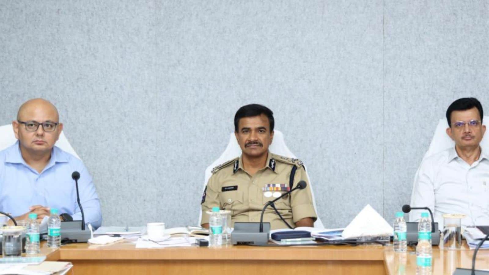 Senior police officer and officials seated at a conference table during a formal meeting.