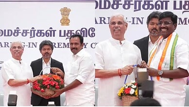 Indian officials and leaders at a formal event, exchanging flowers and gifts on stage.