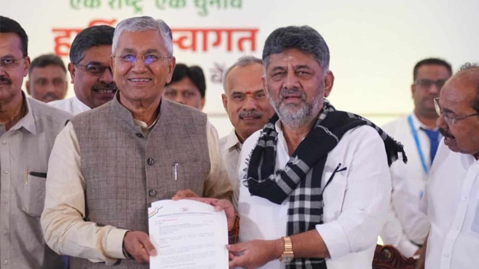 Prominent Indian officials at a public event, exchanging documents and engaging with attendees.