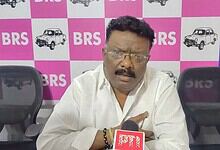 A man speaking into a microphone during a press conference at BRS event.