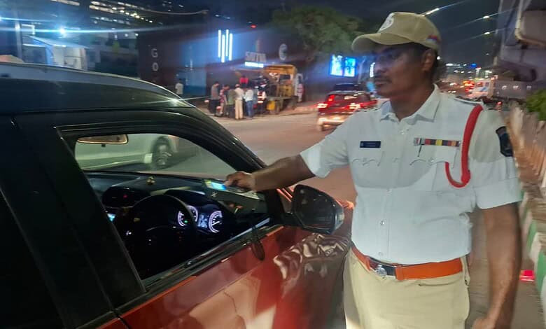 Police officer checking driver for alcohol consumption during a night crackdown.