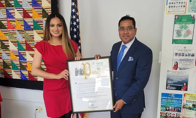 Woman and man holding a framed award at an office event.
