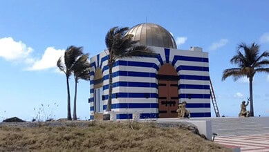 Mosque on Jeffrey Epstein’s island with Islamic artefacts, blue and white stripes, palm trees, and a gold.