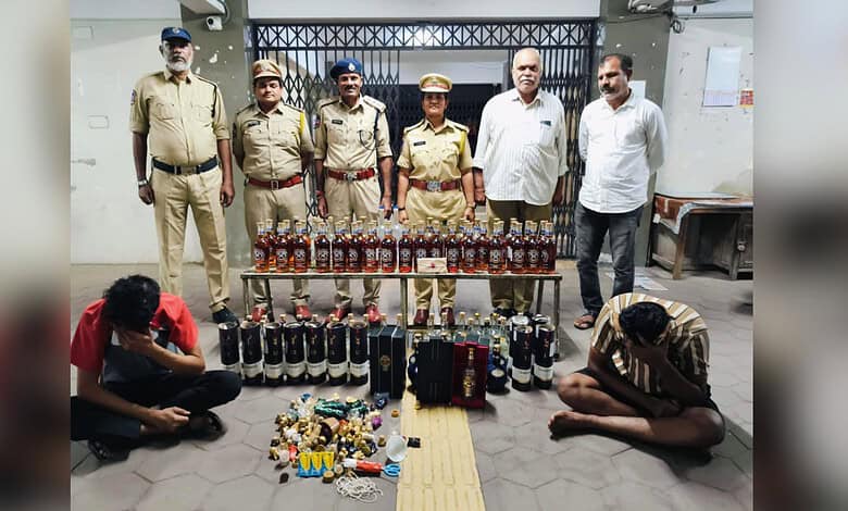 Illegal liquor bust in Hyderabad with police officers and seized bottles displayed.