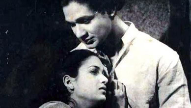 Black and white image of a man and woman in a close, emotional moment, highlighting cultural or historica.