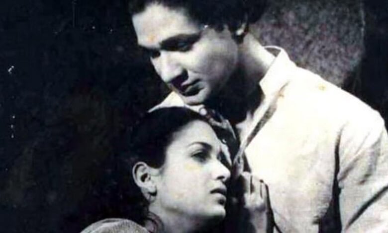 Black and white image of a man and woman in a close, emotional moment, highlighting cultural or historica.