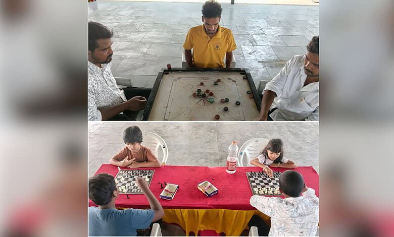 Children playing carrom and chess indoors, engaging in traditional board games for fun and skill developm.