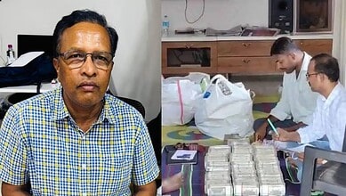 A man in a checkered shirt sitting in an office setting with a serious expression.