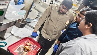 Food safety inspector examining oil quality at KFC outlet in Kondapur, Hyderabad.