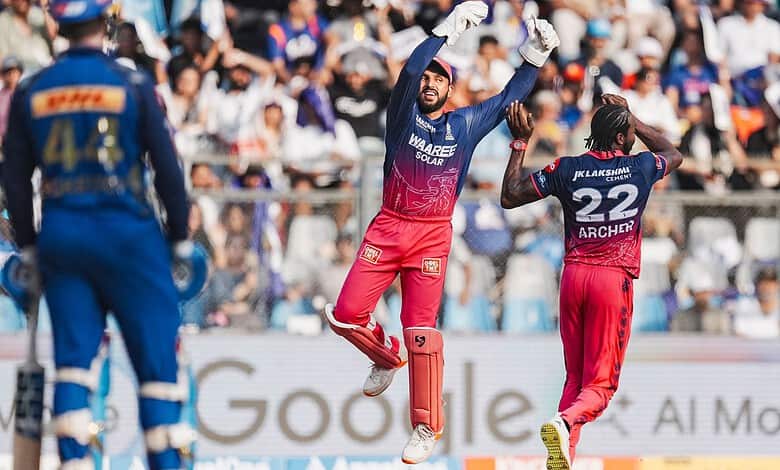 A cricket player celebrating a wicket on the field during a match.