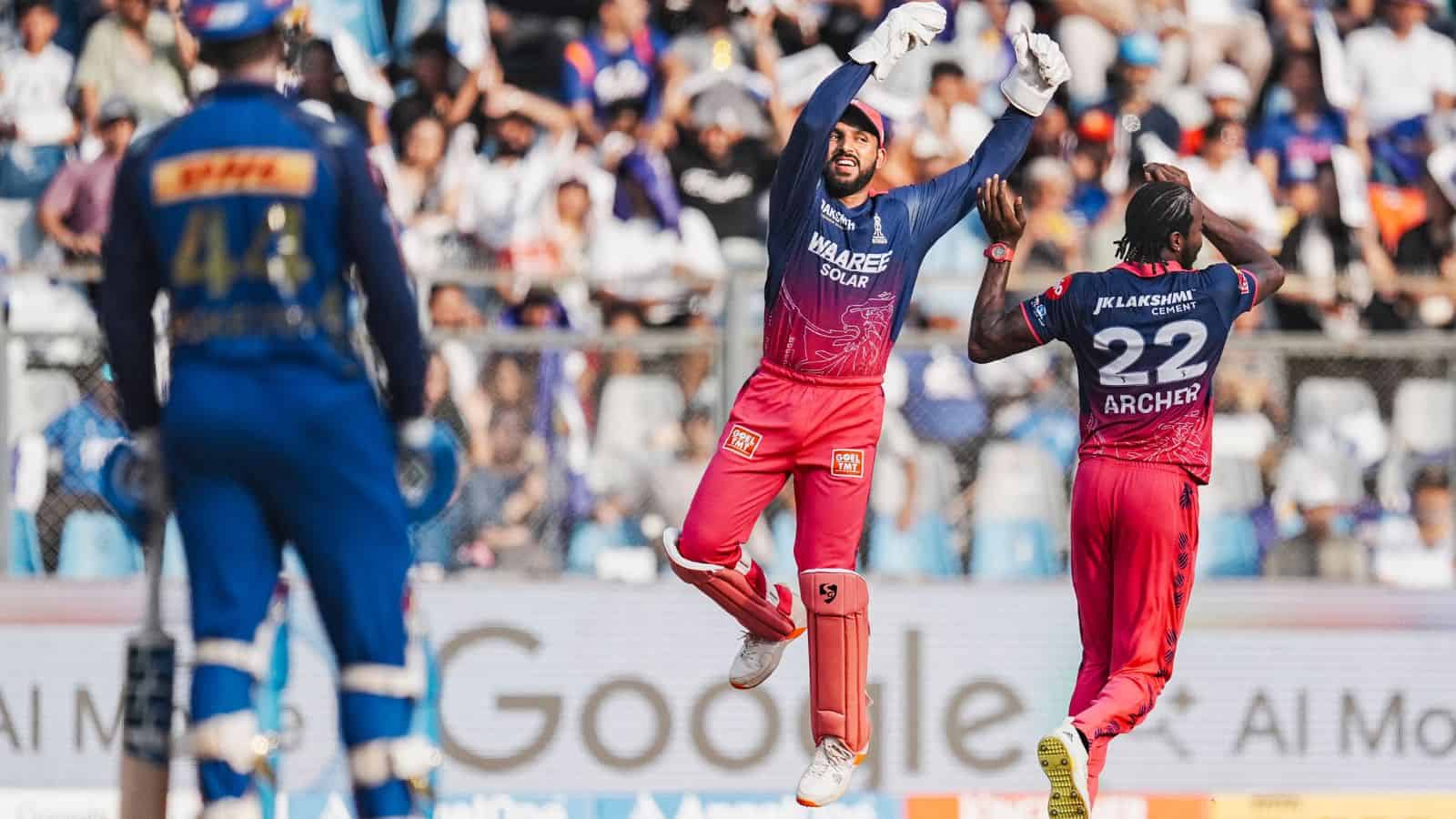 A cricket player celebrating a wicket on the field during a match.