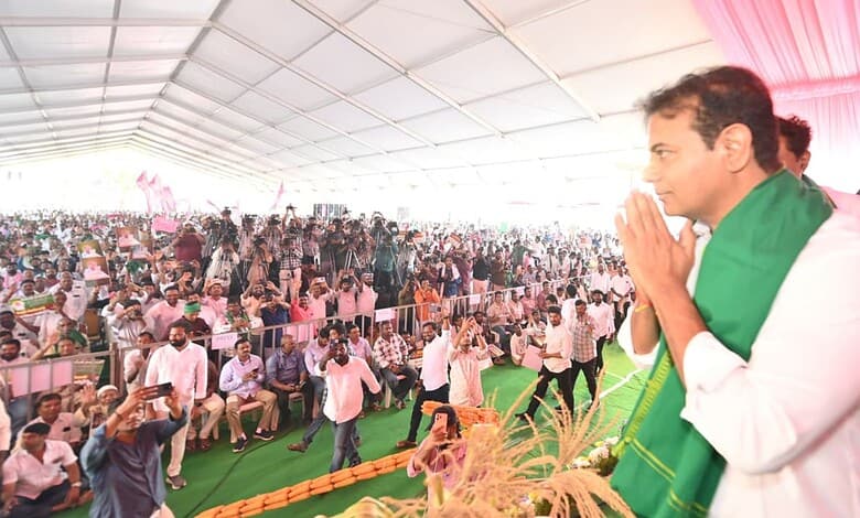 KTR praying with farmers at a large outdoor gathering under a tent.