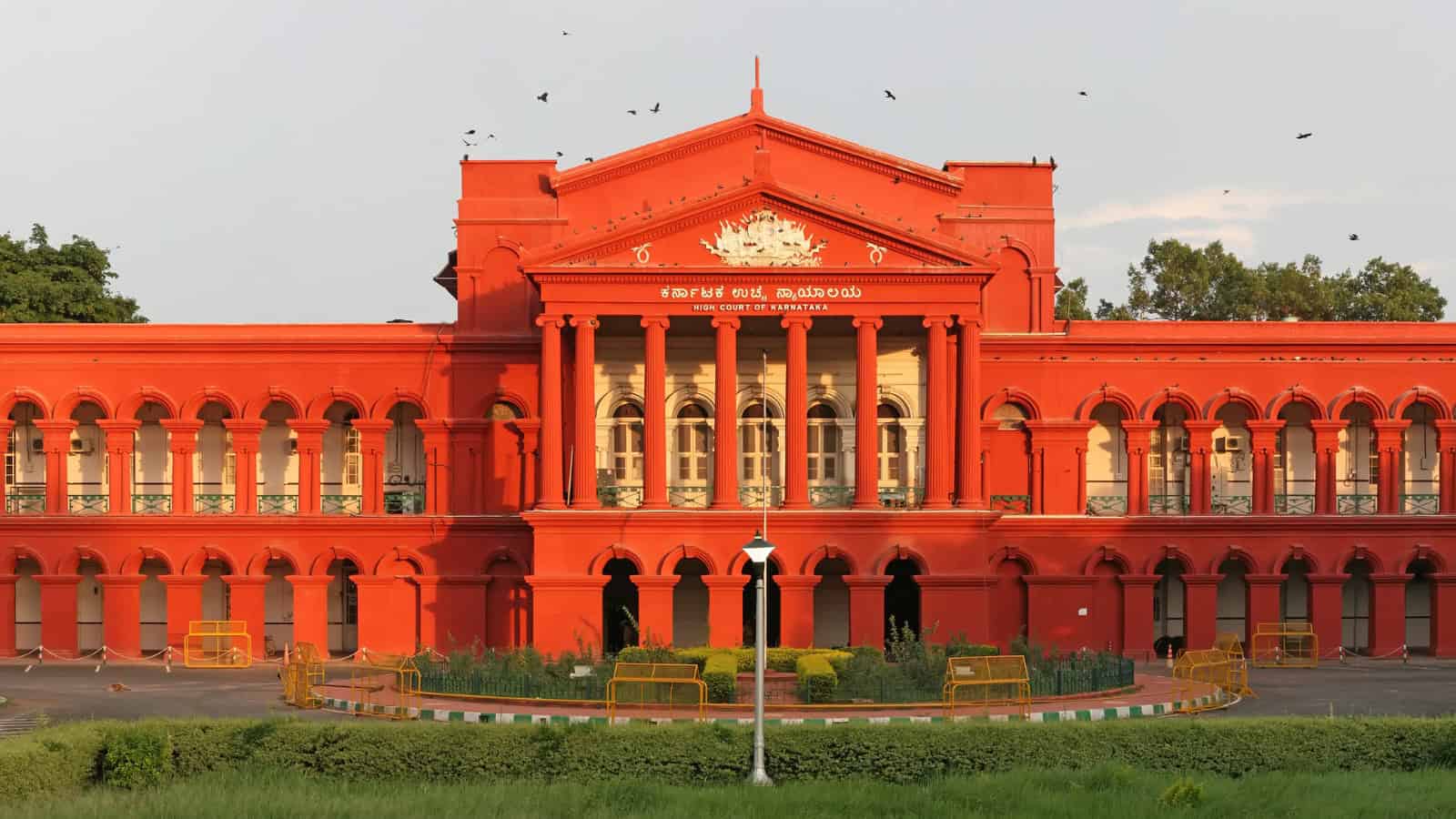 Historic red building with classical architecture, featuring columns and ornate details, set against a cl.