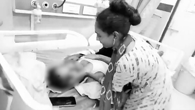 Farmer woman tending to injured person after shed collapse due to heavy winds in Telangana.