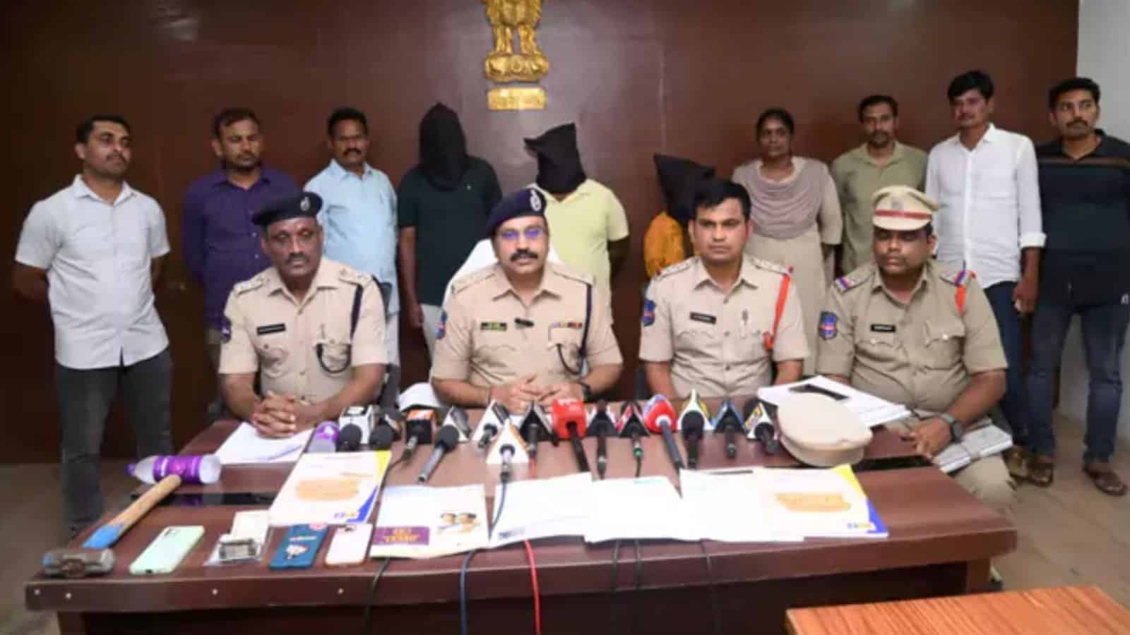 Police officials with detained suspects during a press conference.
