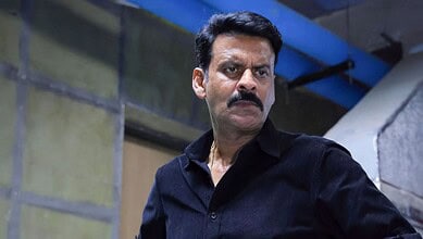 Indian actor with mustache in a black shirt, serious expression, indoor setting, cinematic scene.