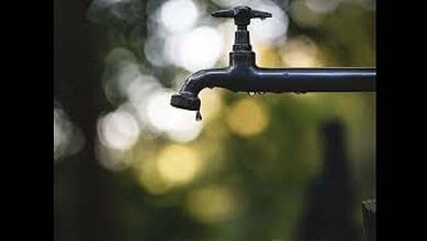 Outdoor water tap with a blurred natural background, eco-friendly water conservation concept.