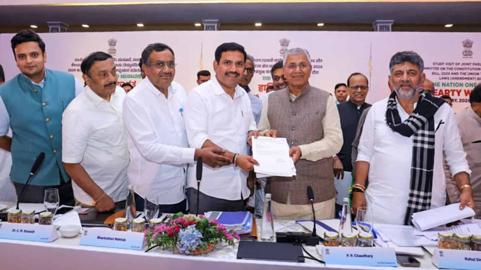 Prominent officials at a formal signing event, celebrating a partnership or agreement, with a decorated t.