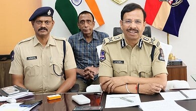 Police officers in uniform sitting at a desk with flags in the background, smiling during a formal meetin.