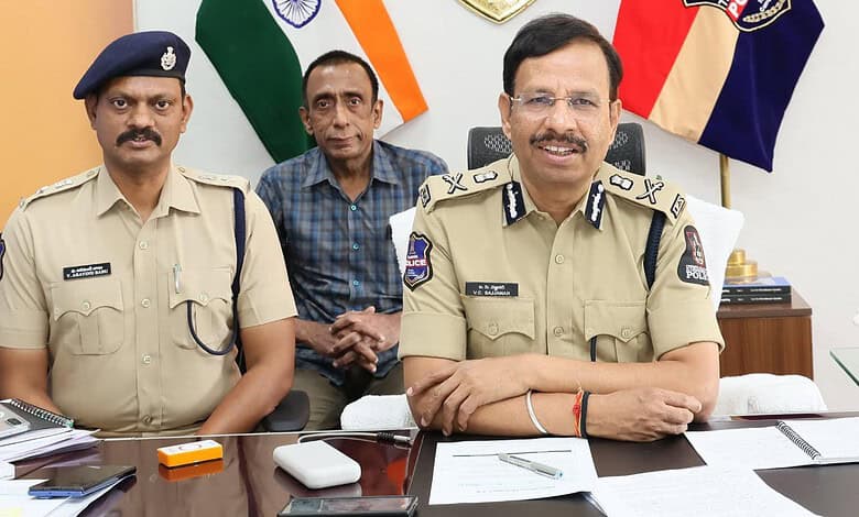 Police officers in uniform sitting at a desk with flags in the background, smiling during a formal meetin.