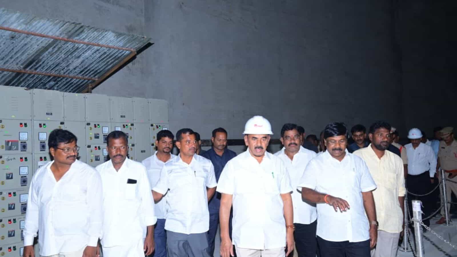 Group of men in white shirts and safety helmets touring an industrial facility.