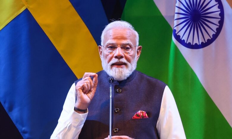 Indian Prime Minister Narendra Modi speaking at a diplomatic event with Sweden and India flags in the bac.