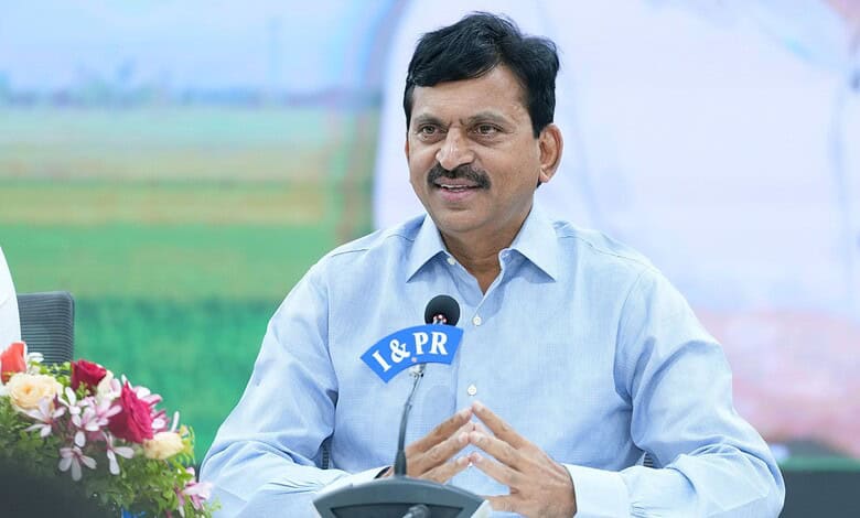 Indian Agriculture Minister speaking at a press conference outdoors with a microphone and flowers in the.
