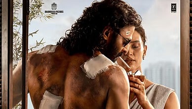 A man with a painted back and a woman lighting a cigarette together outdoors.