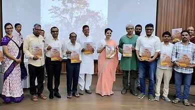 A woman in a peach saree and men in formal attire holding copies of The Siasat Daily at a book launch eve.