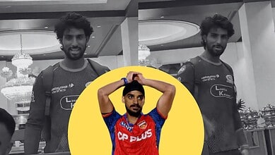 A young male athlete in a sports jersey with a serious expression, standing indoors with elegant chandeli.