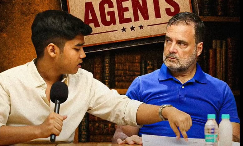 A young man interviewing an older man at a press conference or media event, with a sign reading "AGENTS".