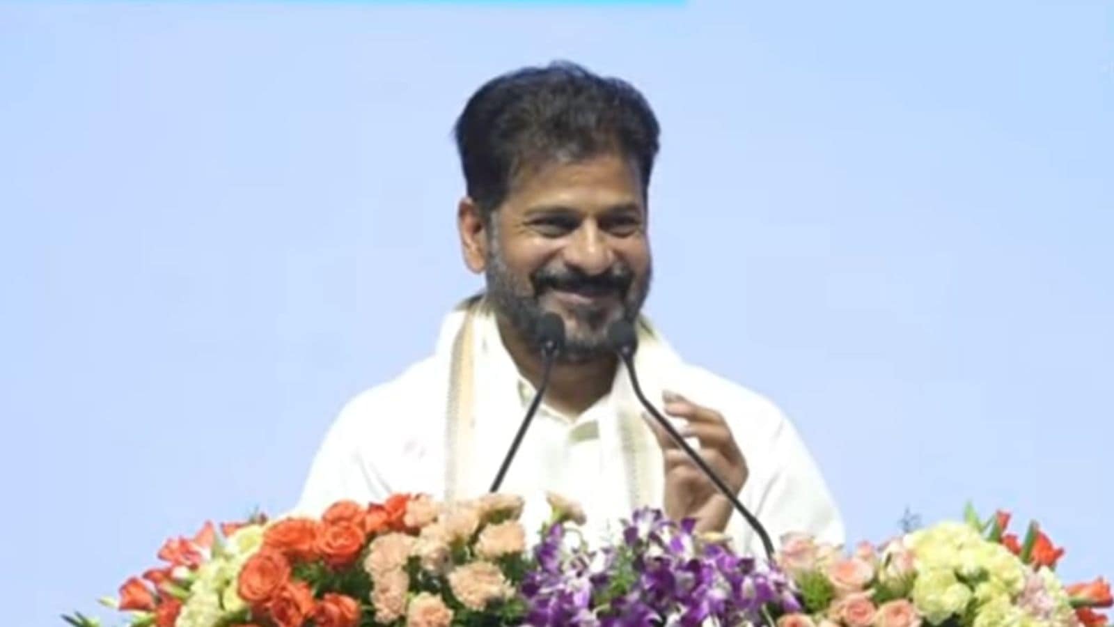 The image shows Telangana CM A Revanth Reddy addressing the launch of Education Week as part of the 99-day action plan held at LB Stadium on Monday, May 11, 2026.