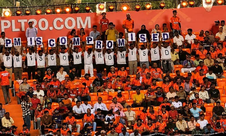 Protesters display signs reading "PM IS COMMITTED" at a political rally, highlighting public support and.