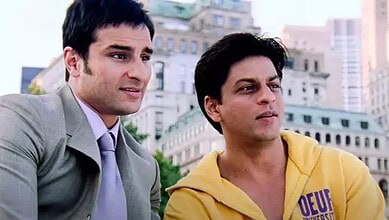 Young men sitting outdoors in an urban setting, engaging in conversation, with city buildings in the back.