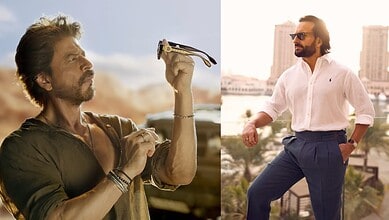 A man with a beard and sunglasses holding a camera outdoors during sunset.