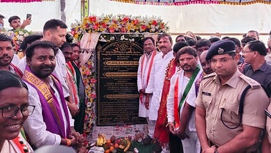 A commemorative event with officials and community members unveiling a plaque at a public gathering.