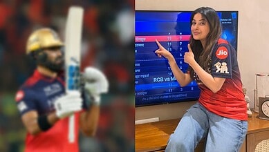 Female cricket player in uniform holding a bat, celebrating a win with a thumbs-up gesture.