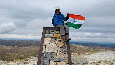Young boy from Siddipet, Telangana, holding Indian flag at Australia's highest peak.