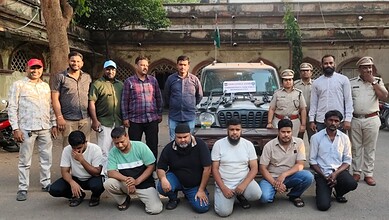 Group of men and police officers posing with seized vehicles after illegal deer and peacock hunting in Te.