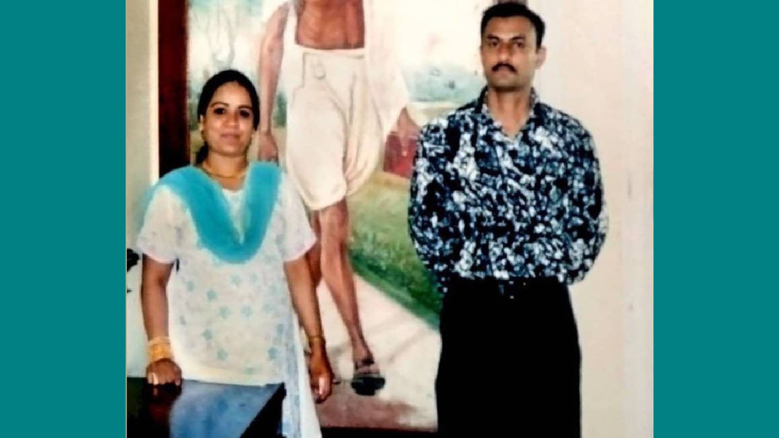 Two individuals standing in front of a mural, related to the 2005 fake encounter of Sohrabuddin Shaikh.
