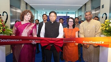 Group of diverse professionals at Southwest Airlines event, ribbon-cutting ceremony in modern airport ter.