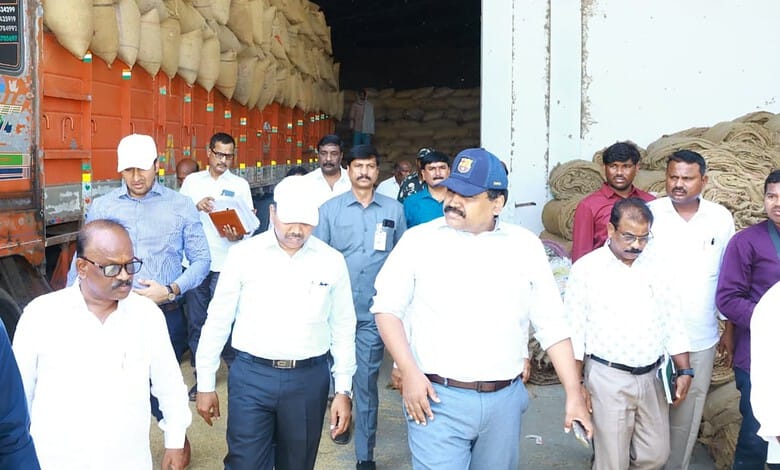 Civil Supplies Commissioner inspecting paddy at procurement centre with officials and workers present.