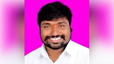 Bright smiling man with dark hair and beard wearing a white shirt against a vibrant pink background.