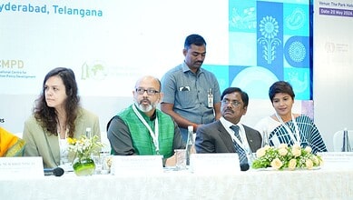 Panel discussion at Hyderabad conference with diverse speakers and floral decor.