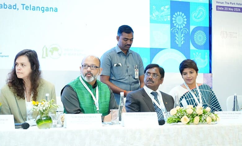Panel discussion at Hyderabad conference with diverse speakers and floral decor.