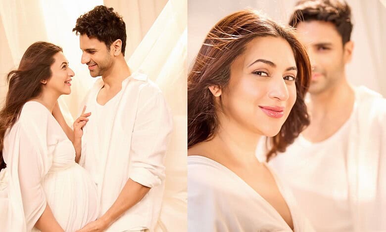 A pregnant woman and her partner smiling and looking at each other in a bright, cozy room.