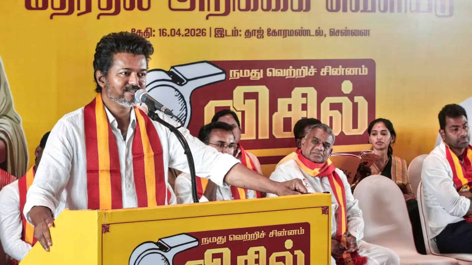TVK leader speaking at Tamil Nadu election rally with supporters, promoting promises of gold and free cyl.