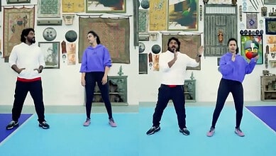 Four dancers performing in an art gallery with various paintings and artworks on the wall behind them.
