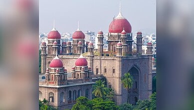 A grand historic fort with red domes and lush greenery in the foreground, showcasing traditional Indian a.